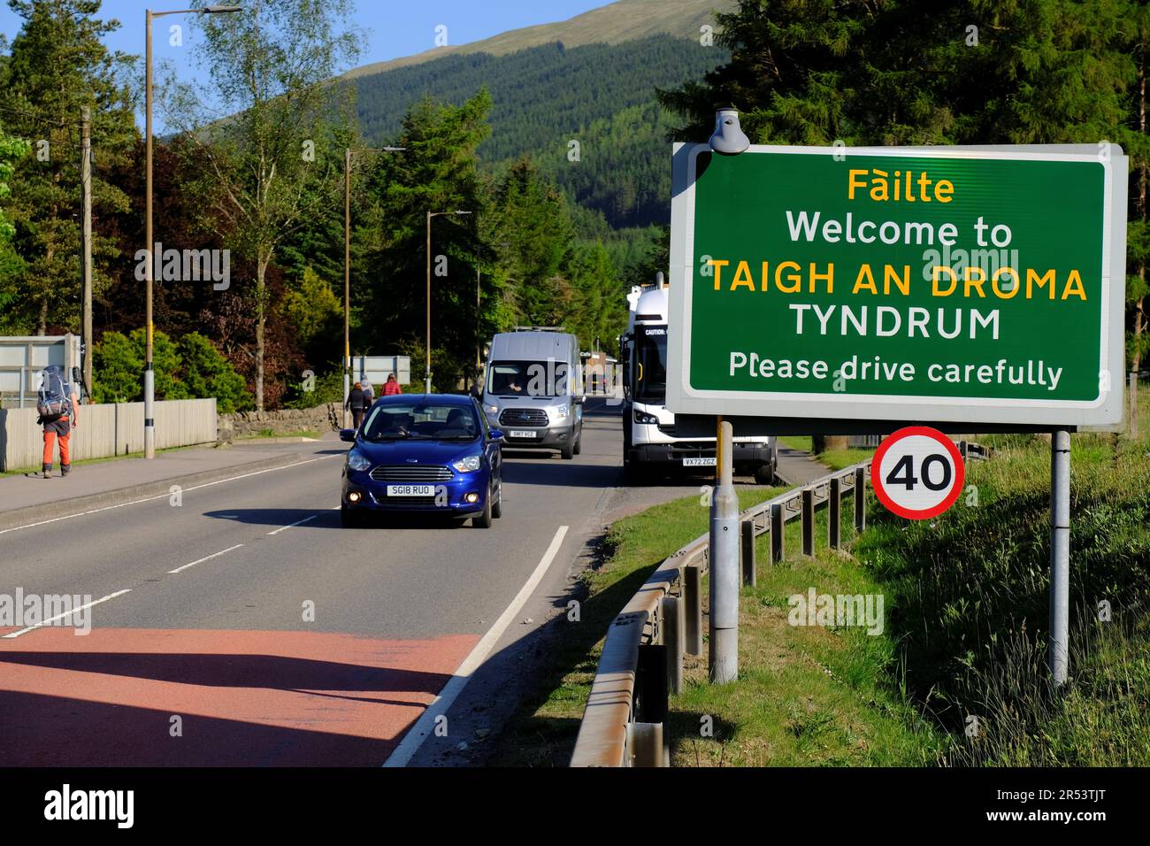 Ciel bleu clair et soleil éclatant à Tyndrum, voitures sur la route A82 Tyndrum, Écosse Banque D'Images