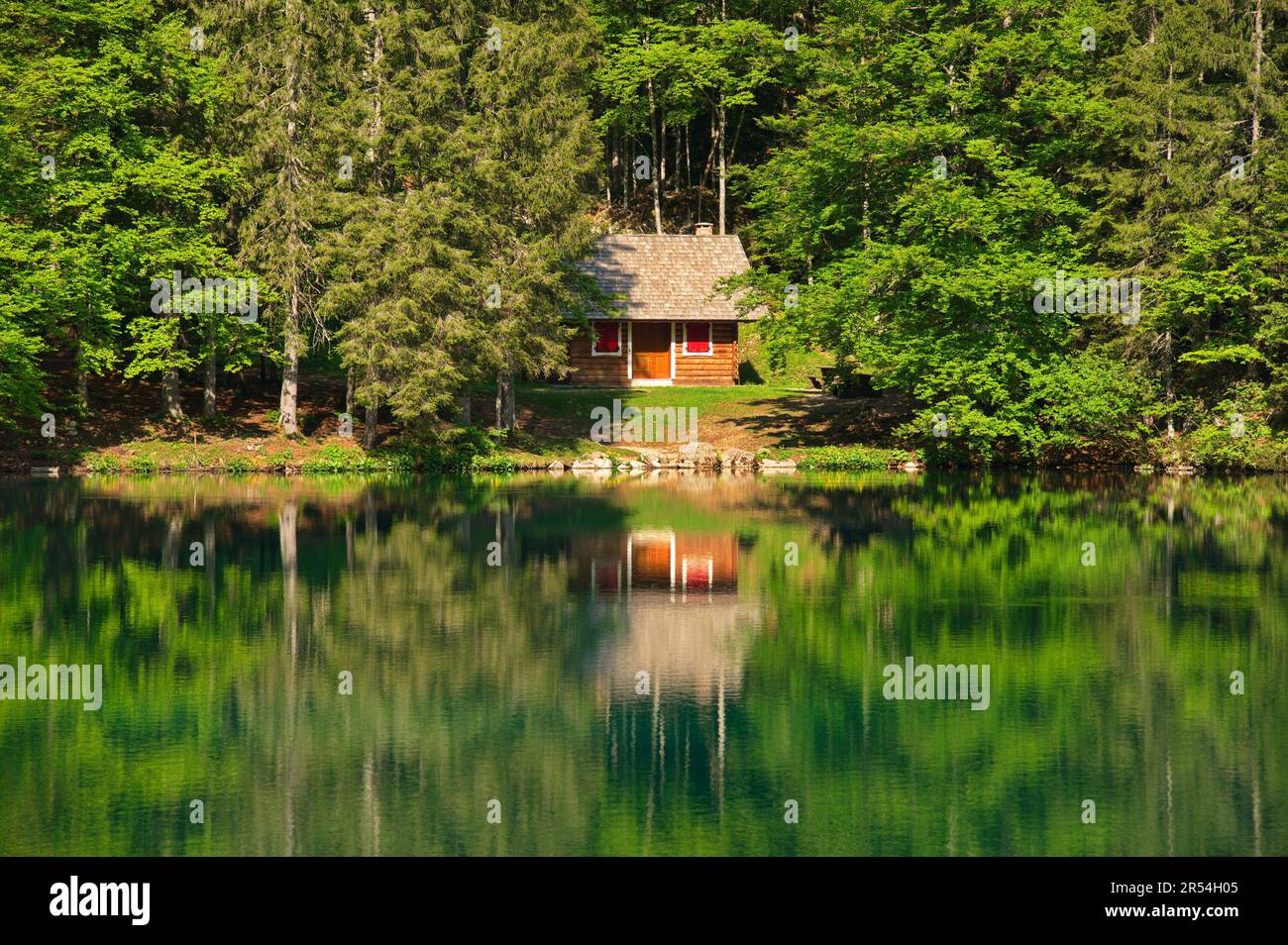 Chalet en bois au lac réfléchi dans l'eau Banque D'Images