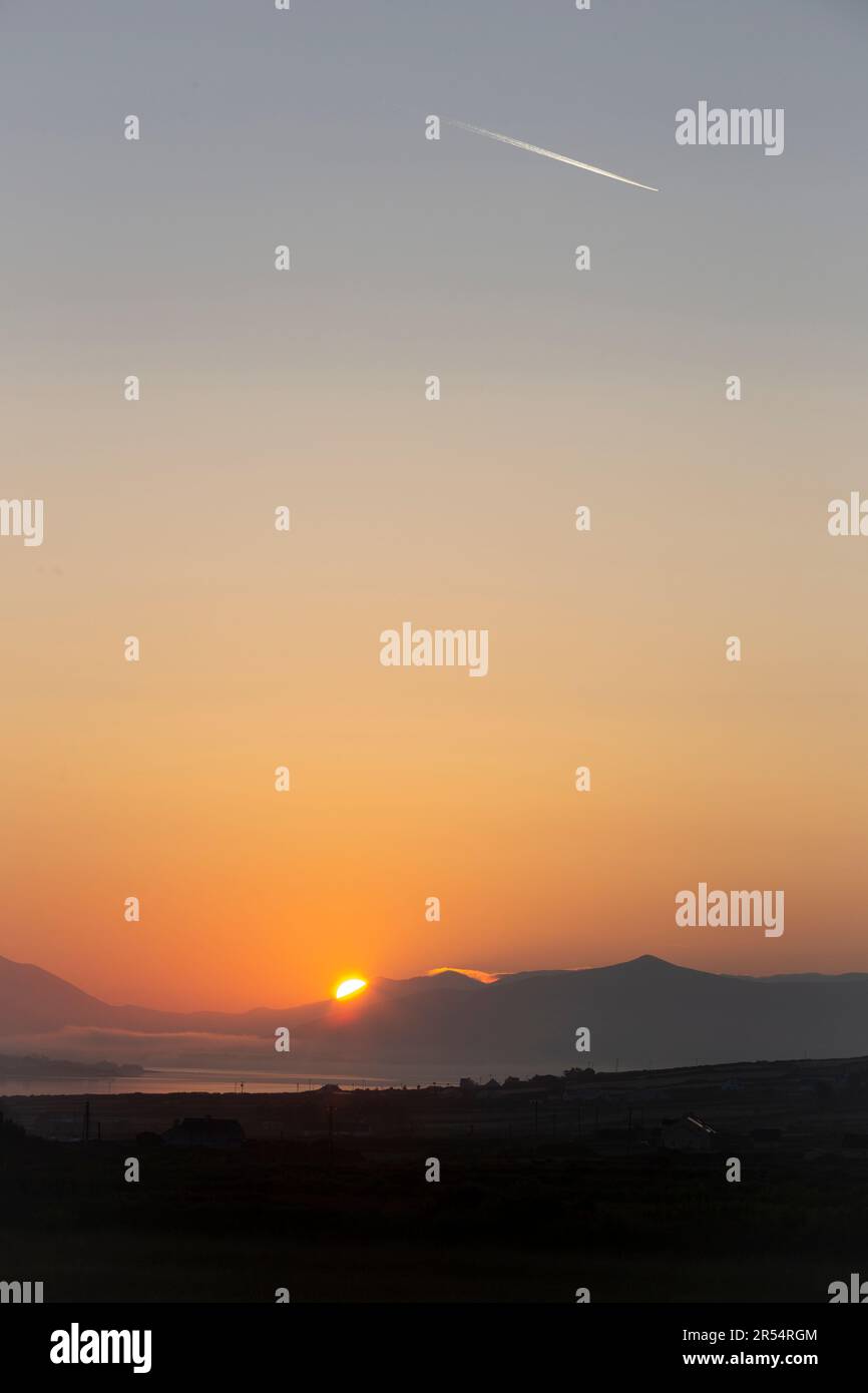 Portmagee, comté de Kerry, Irlande. 1st juin 2023. Magnifique lever de soleil doré et jet Trail au-dessus du canal de Portmagee pour annoncer le premier jour de juin. Crédit photo : Stephen Power / Alamy Live News Banque D'Images