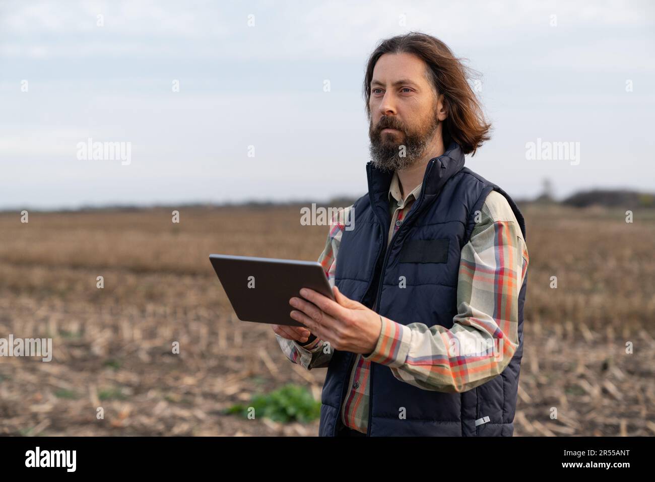 Agriculteur avec une tablette numérique dans un domaine agricole. Agriculture intelligente et agriculture numérique. Photo de haute qualité Banque D'Images