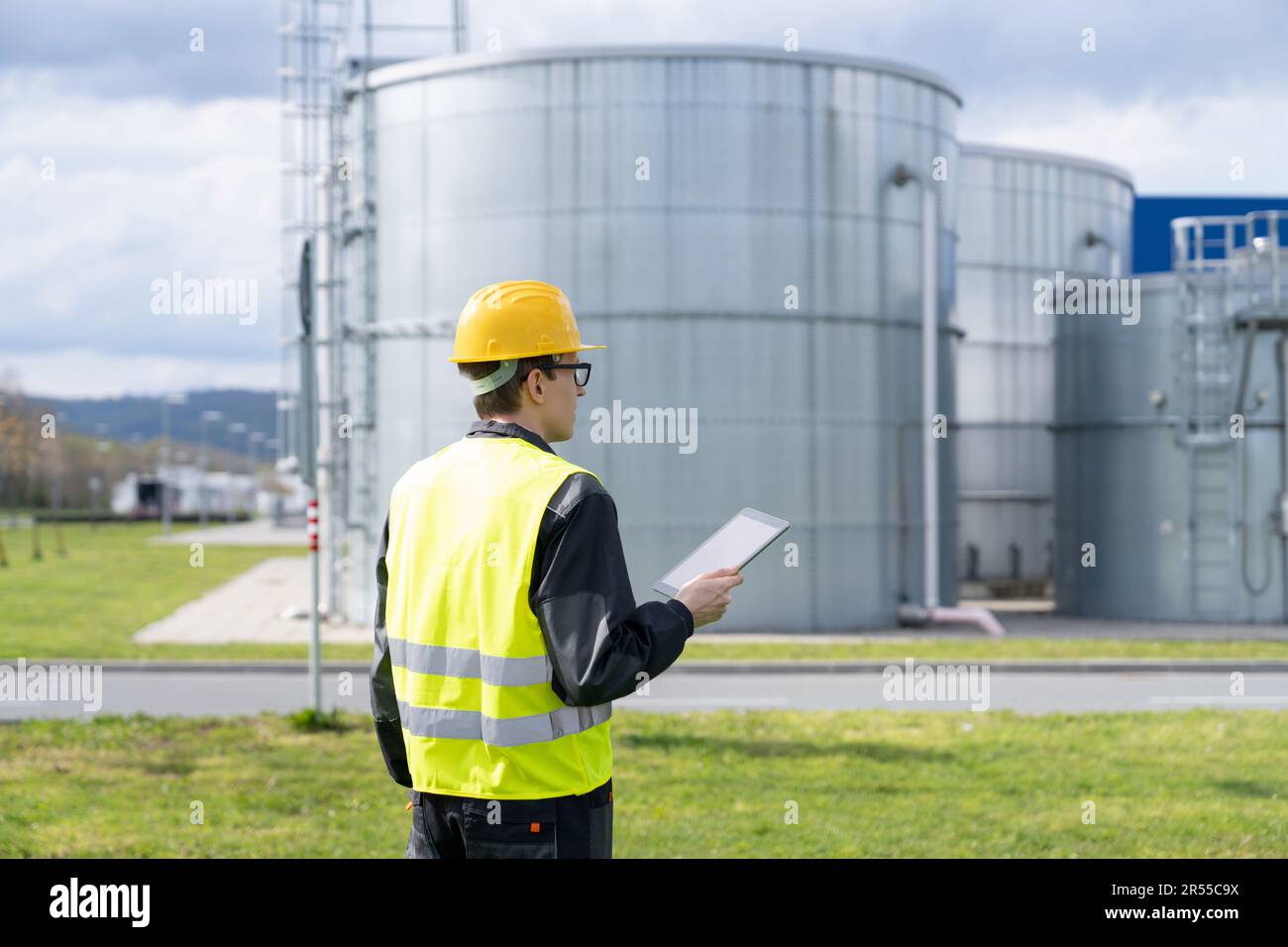 Concevoir avec une tablette numérique sur un fond de réservoirs de gaz. Photo de haute qualité Banque D'Images