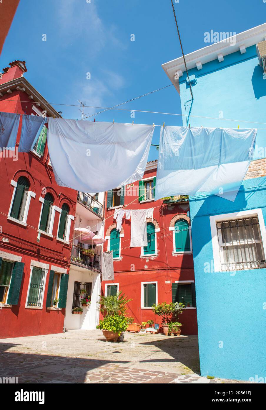 Étroites vieilles rues de l'île de Burano avec des maisons colorées et des draps de séchage à charnières, Venise, Italie. Destination de voyage très attrayante et célèbre. Banque D'Images