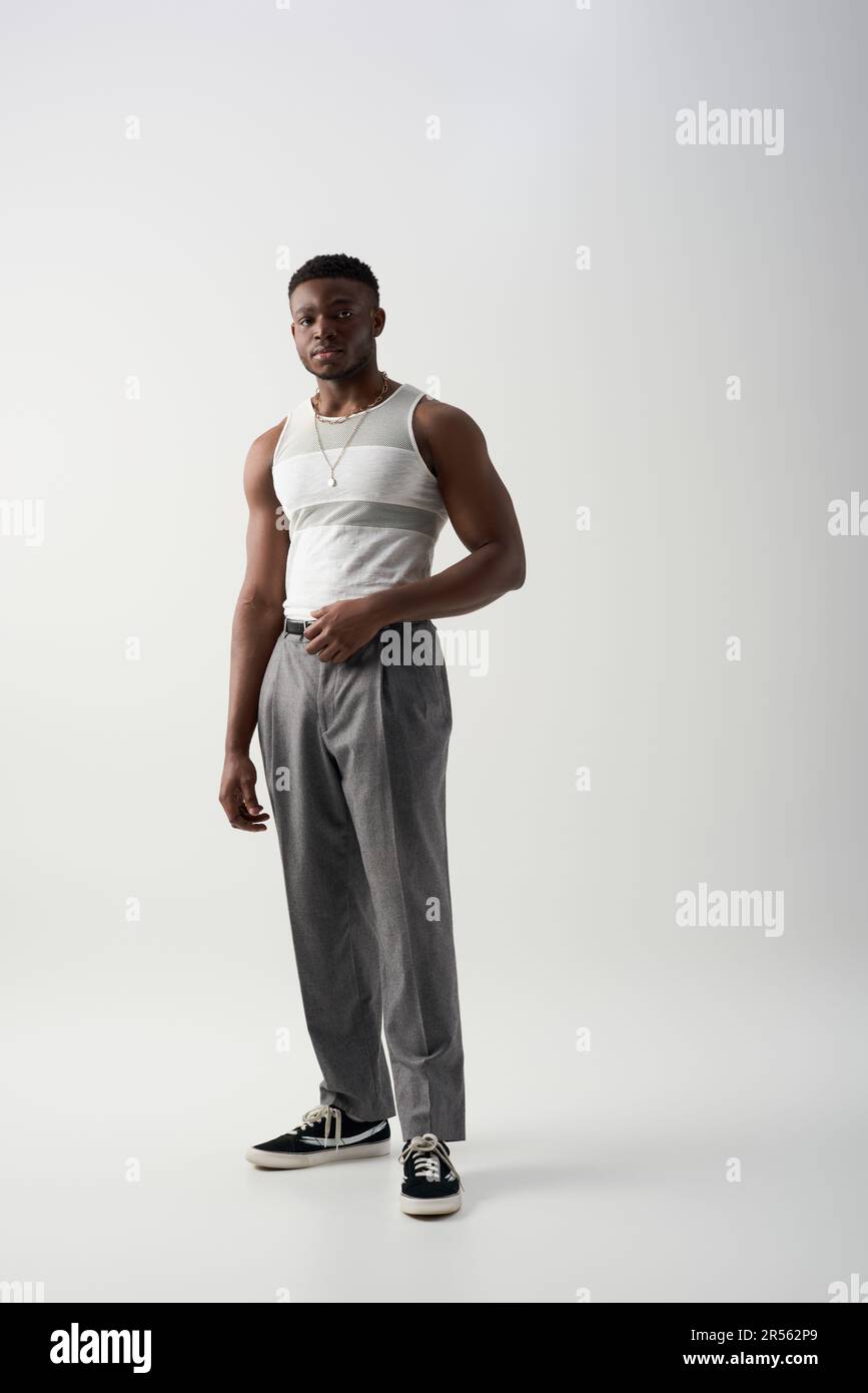Pantalon et t-shirt sans manches pour tout jeune homme afroamerican  regardant l'appareil photo sur fond gris, ce modèle contemporain est idéal  pour les prises de vue Photo Stock - Alamy