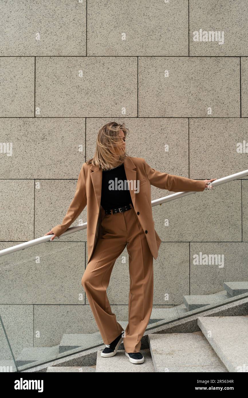 Portrait d'une femme d'affaires en costume de pantalon debout sur des marches à l'extérieur d'un bâtiment, Biélorussie Banque D'Images