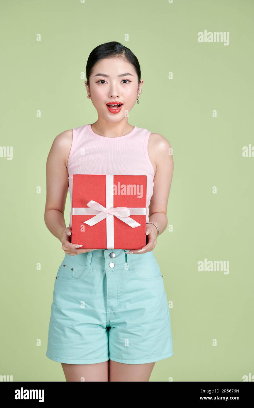 Jolie fille asiatique heureuse avec un cadeau dans les mains de, l'isolement Banque D'Images