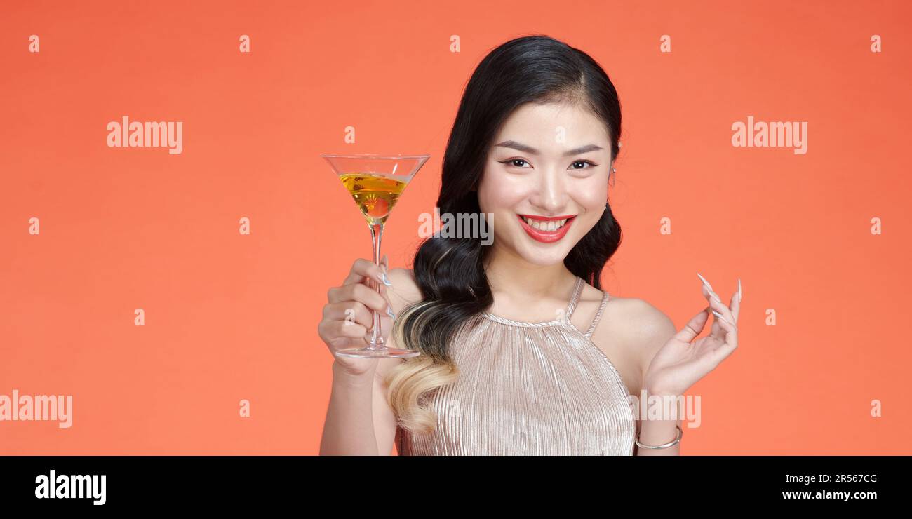 Jeune femme élégante en maquillage du soir tenant un verre de champagne et célébrant Banque D'Images