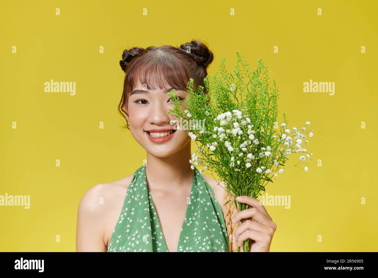 Jeune femme heureuse appréciant le bouquet de fleurs entre les mains Banque D'Images