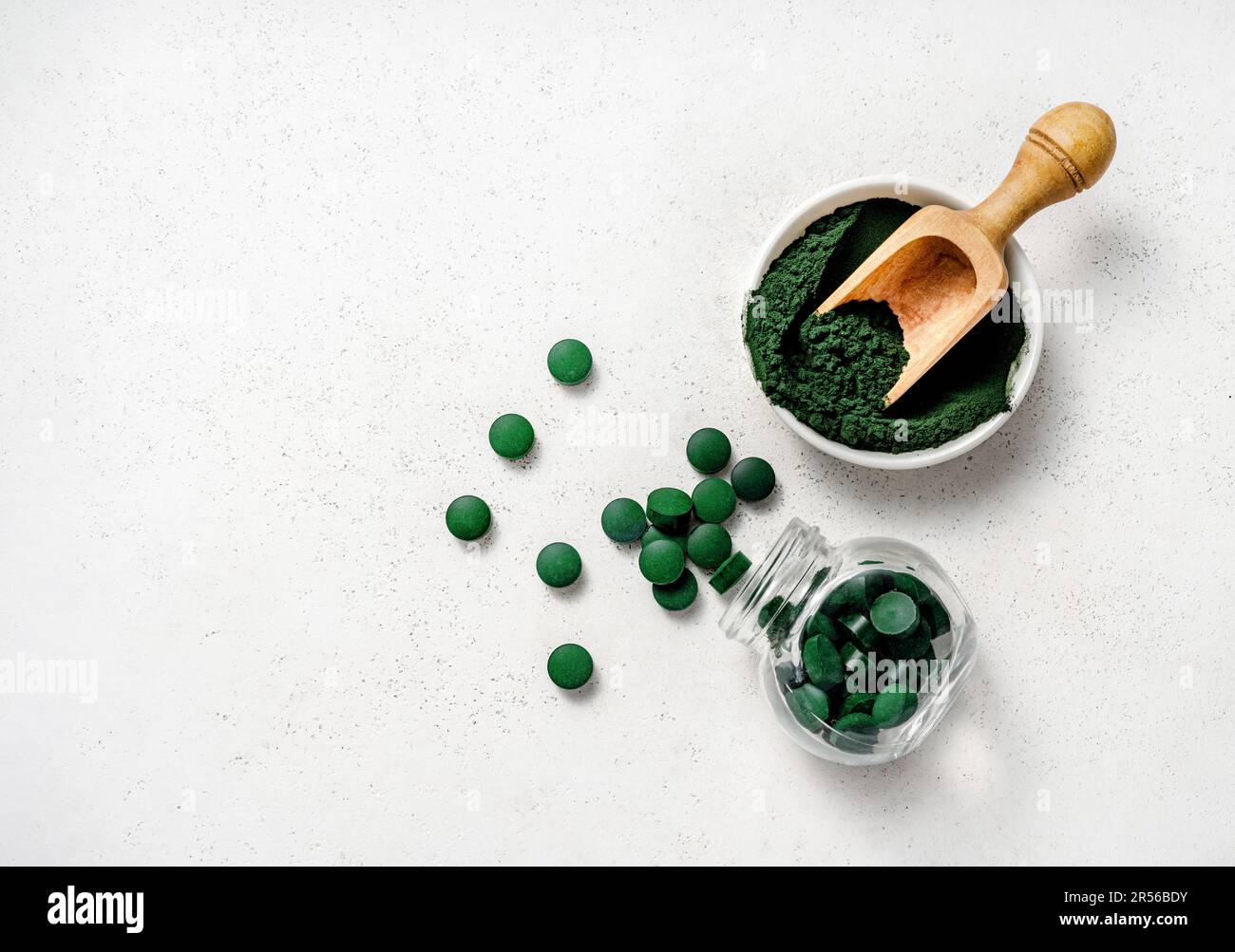Spiruline algues poudre et Spiruline comprimés sur fond blanc. Banque D'Images