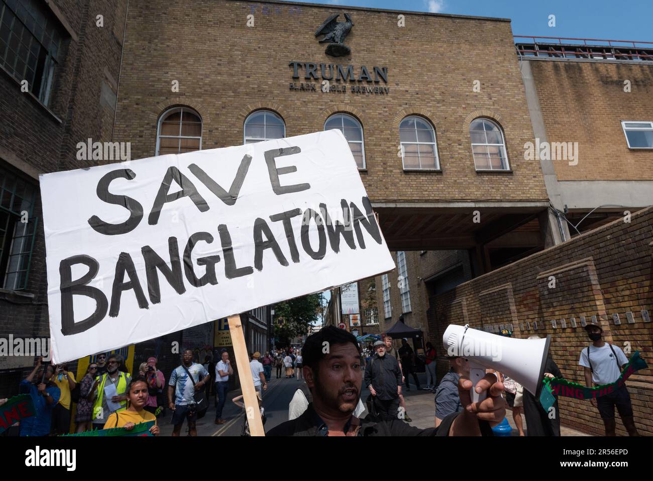 Un activiste tient une affiche « Save Banglatown » au complexe de la brasserie Truman lors d'un rassemblement contre les projets de construction de magasins et de bureaux sur le site. Banque D'Images