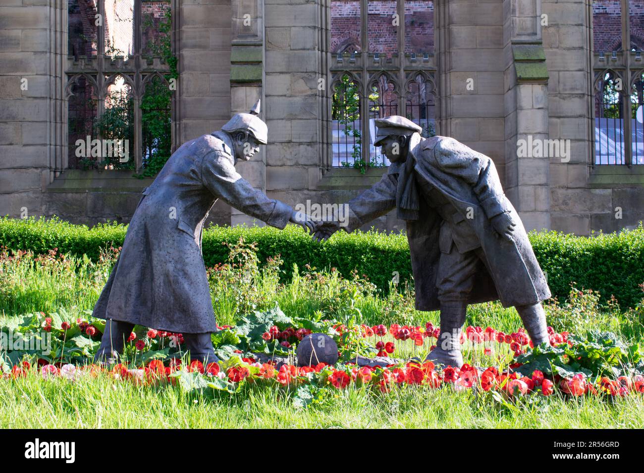 Statue de la Trêve de Noël avec football et poignée de main devant l'église bombardée. Liverpool Royaume-Uni. Banque D'Images