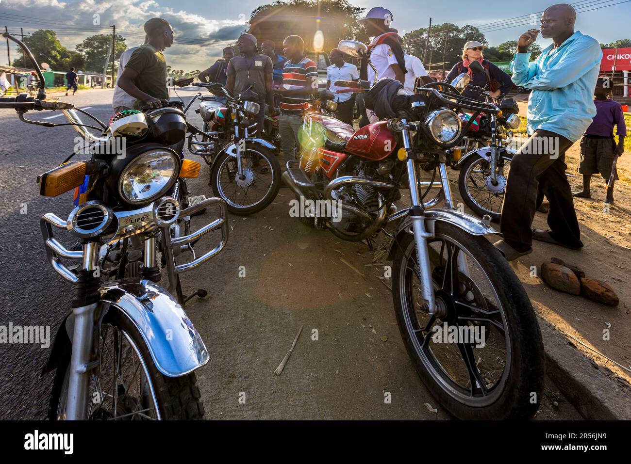 Plusieurs kabaza, comme on appelle les taxis à moto ici, se tiennent avec leurs chauffeurs au bord d'une route dans le district de Machinga, au Malawi ; avant le trajet, le prix est négocié entre le chauffeur et le passager. Banque D'Images