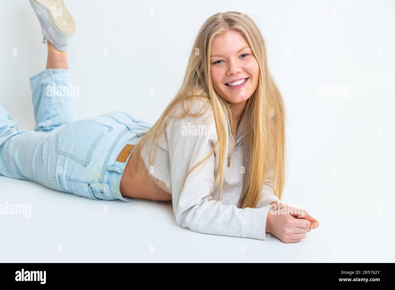 Jeune femme couché sur le front, souriante Banque D'Images