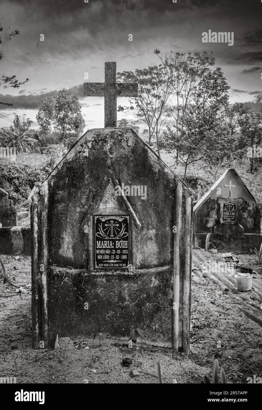 Tombes dans un cimetière catholique en face de l'église catholique Kon XOM Luh, Kon Ray, Kontum, Vietnam. Les tombes les plus pauvres sont simplement recouvertes de fûts d'huile rouillés. Banque D'Images
