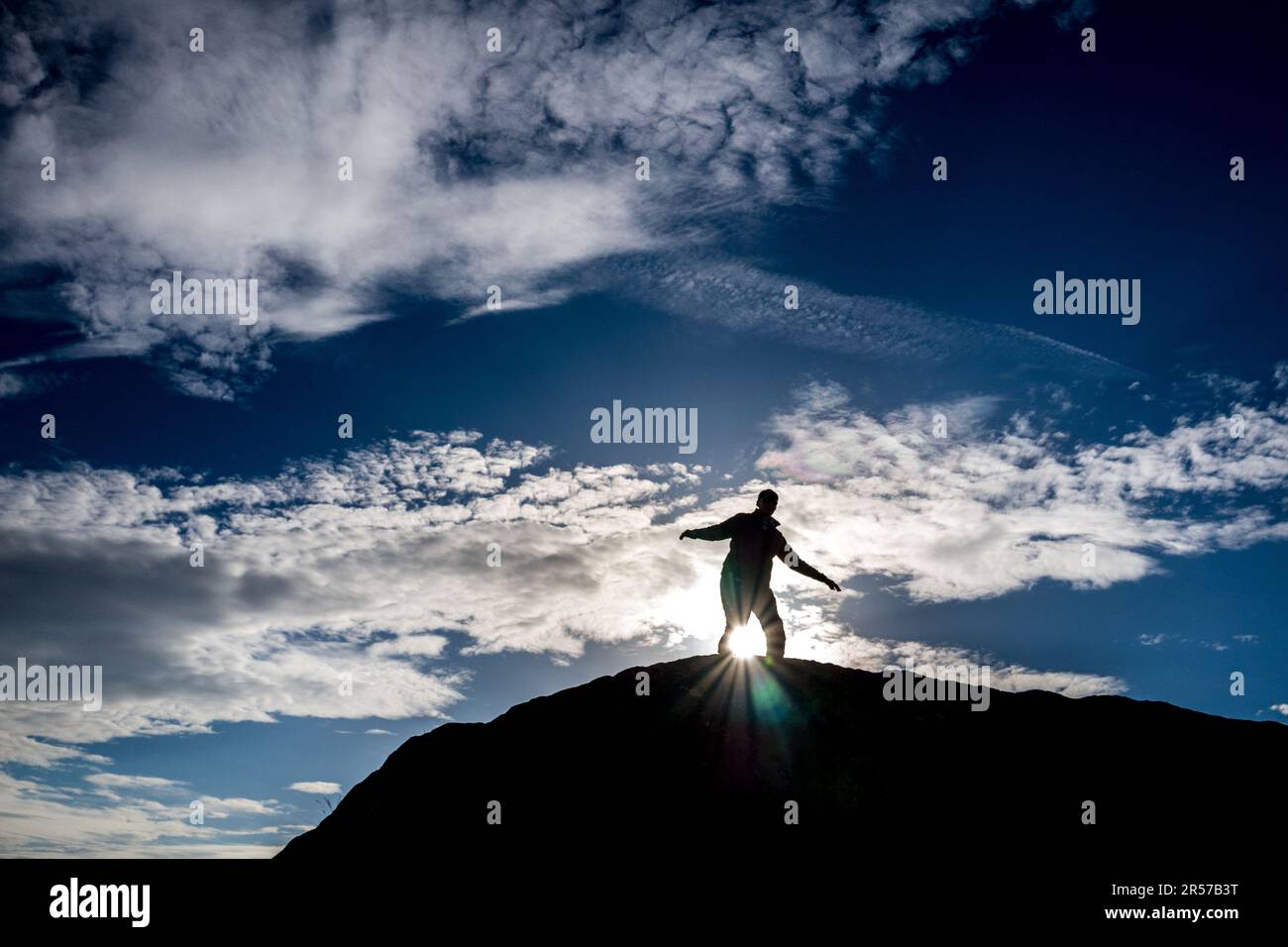 Homme debout au-dessus de la Grande Pierre de Fourstones, ou la Grande Pierre qui est un dépôt glaciaire sur les landes de Tatham Fells, Angleterre. Banque D'Images