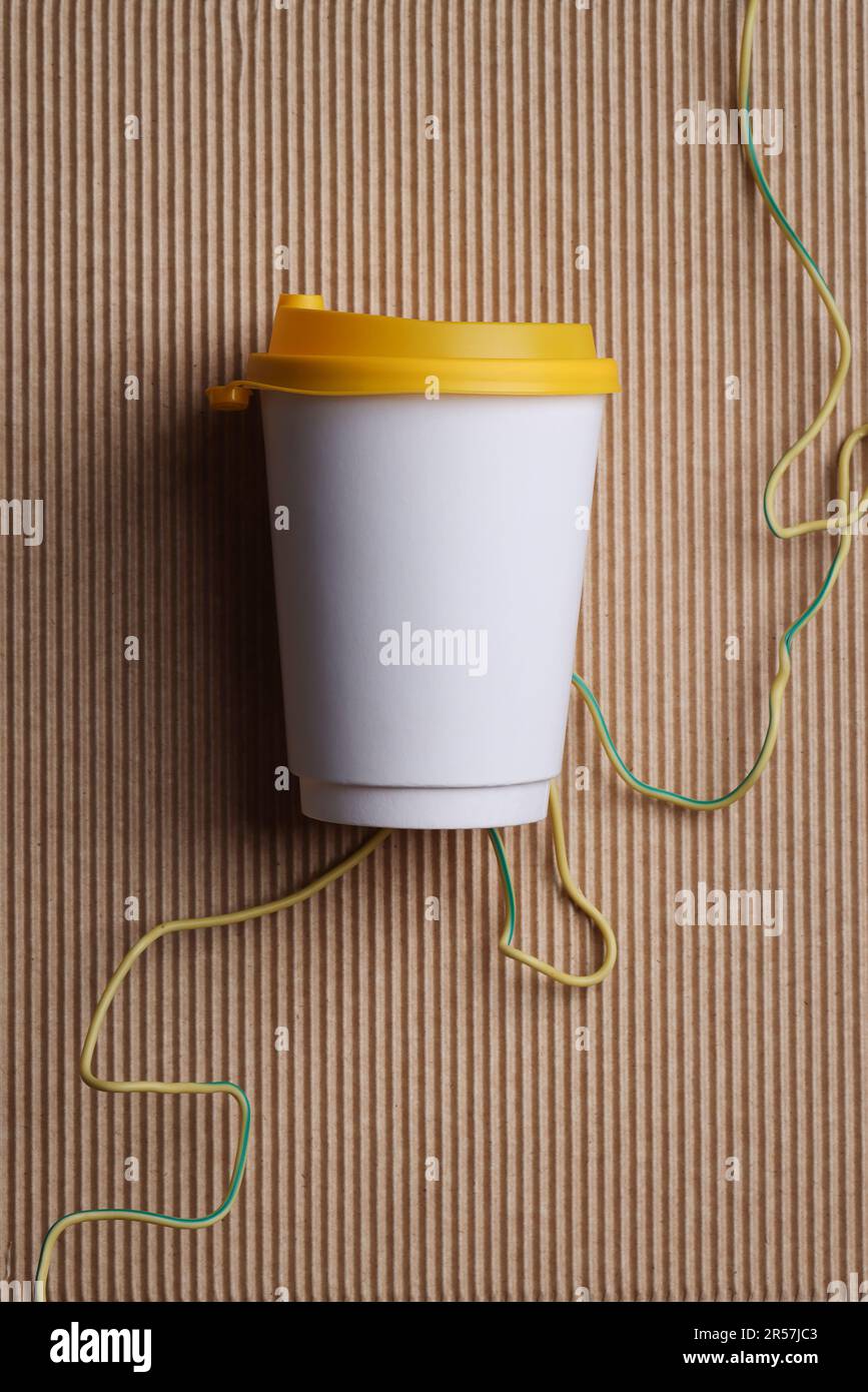 Blanc blanc blanc papier à emporter gobelet de recyclage avec couvercle jaune sur fond marron nervuré , maquette , modèle, espace pour votre texte , publicité. Banque D'Images