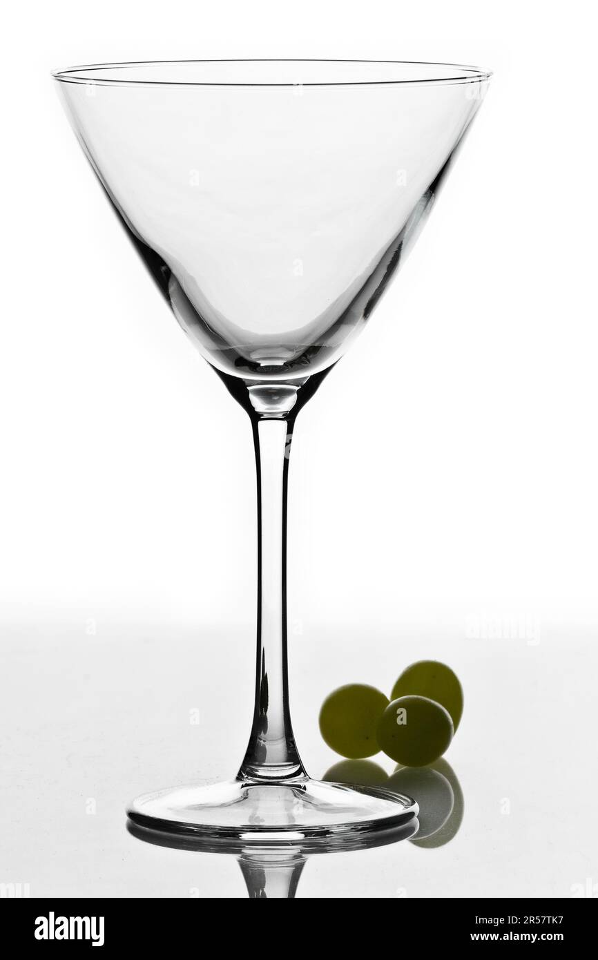 Verre à cocktail isolé sur fond blanc avec des raisins verts Banque D'Images