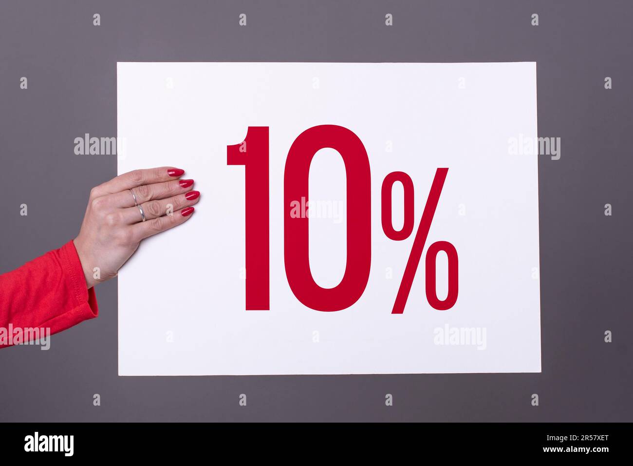 Main féminine tenant une affiche à 10 %. Prise de vue en studio. Concept commercial Banque D'Images