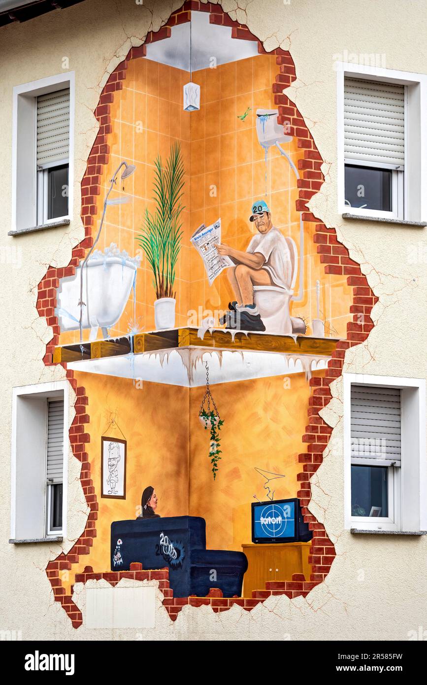 Maison avec drôle de peinture murale, vue à l'intérieur, homme lisant le journal sur les toilettes, femme dans le salon regardant la scène de crime sur la télévision, curieux, drôle Banque D'Images