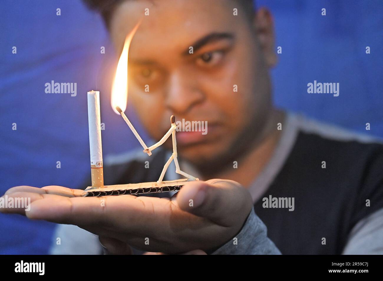 Bijoy Debnath, un artiste de 21 ans qui présente son œuvre d'art créée avec des allumettes et des cigarettes représentant un homme de allumettes tuant une cigarette avec une épée dans le cadre d'une campagne « cesser de fumer » à la veille de la « Journée mondiale sans tabac ». 31 mai est célébrée comme la Journée mondiale sans tabac pour sensibiliser à la consommation de tabac dans le monde entier. Agartala, Inde. Banque D'Images