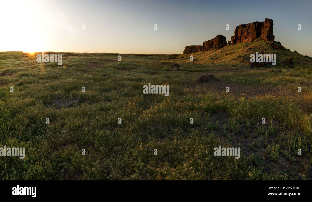 Basalt butte s'élevant au-dessus des prairies du désert au coucher du soleil, zone de faune des lacs de mer, Washington, États-Unis Banque D'Images