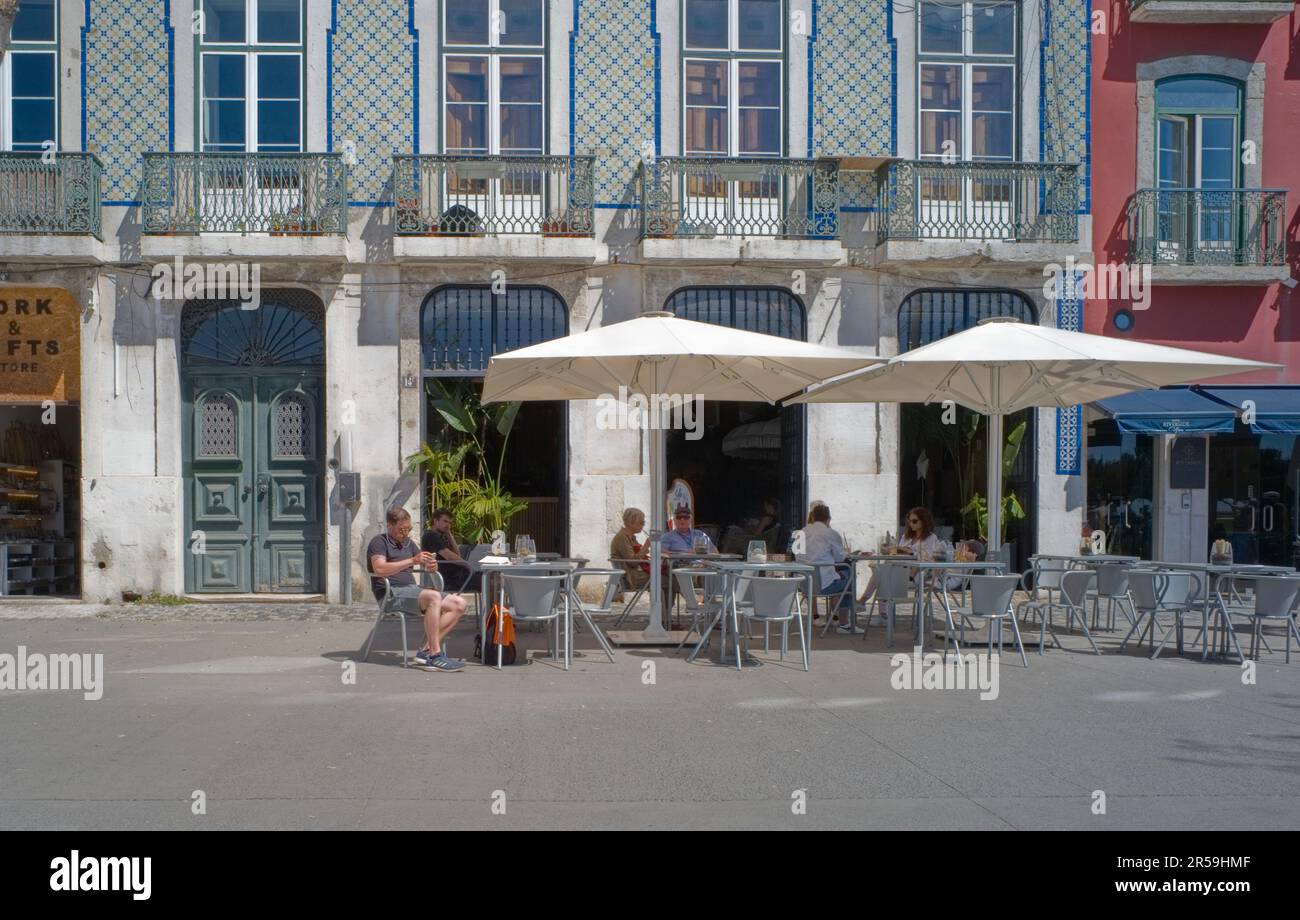 Touristes dans un café en plein air dans le quartier d'Alfama à Lisbonne Banque D'Images