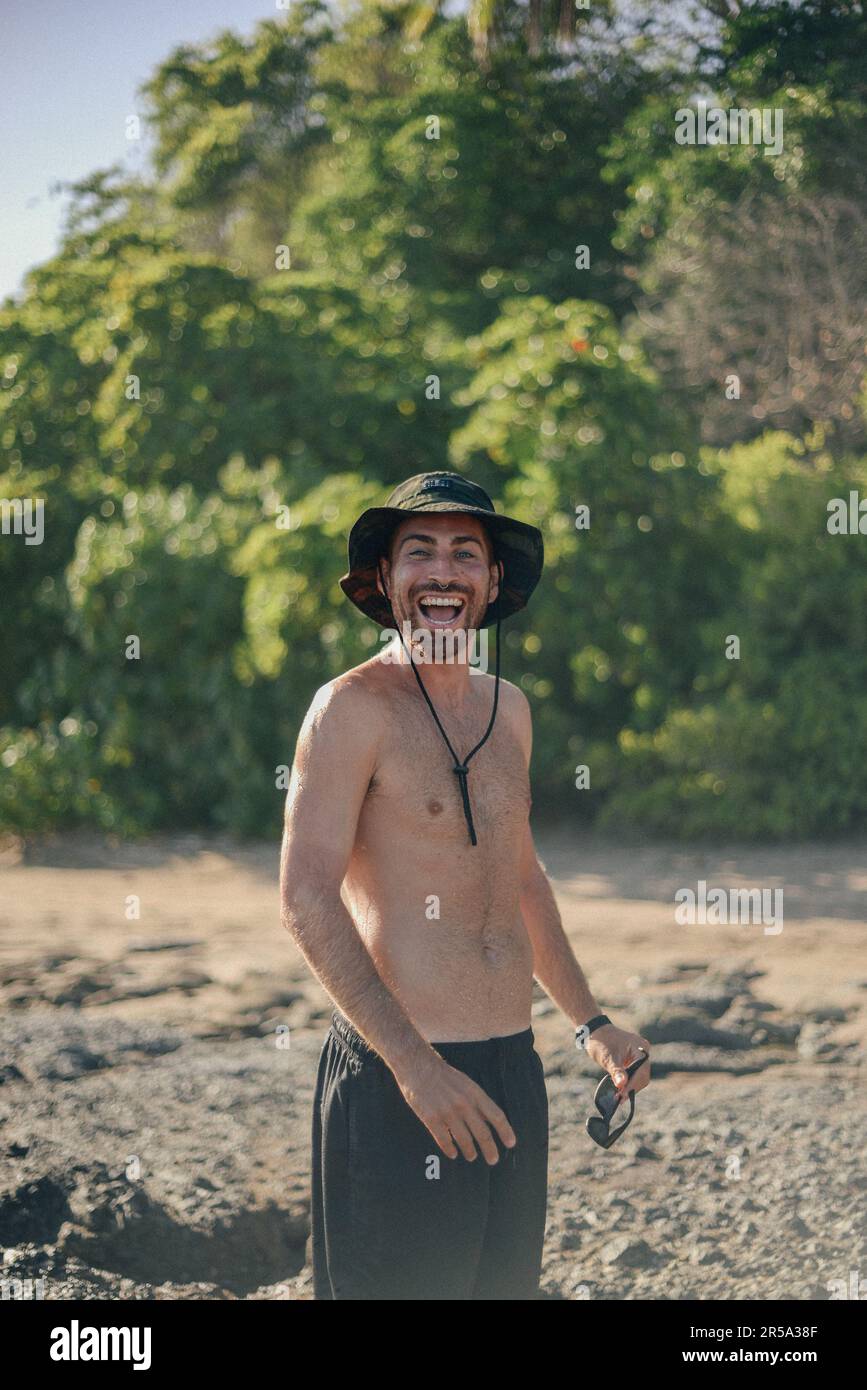 un garçon avec un grand sourire appréciant une journée de plage Banque D'Images