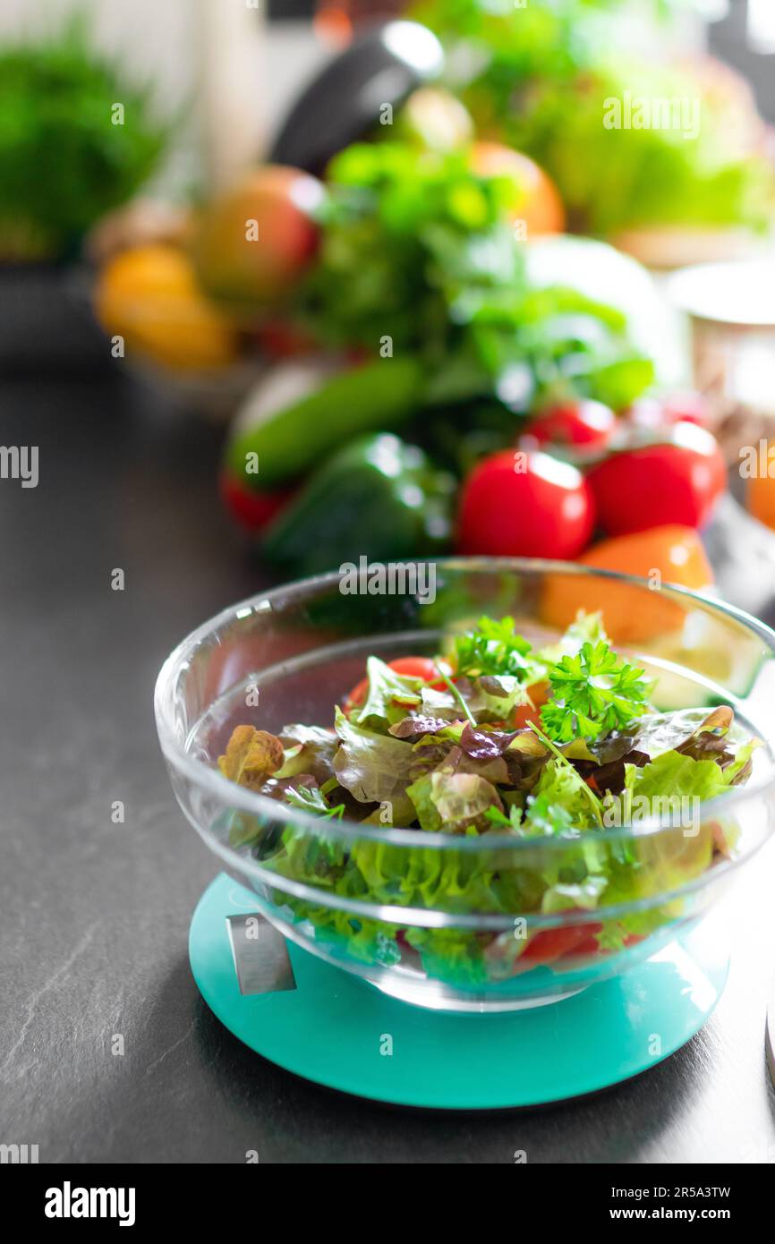 Un gros plan d'une salade fraîche et saine sur une balance de cuisine Banque D'Images