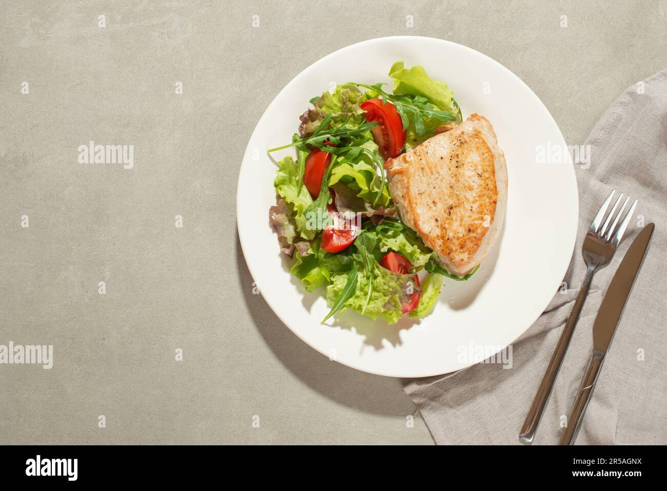 Salade avec légumes et poulet sur fond gris Banque D'Images