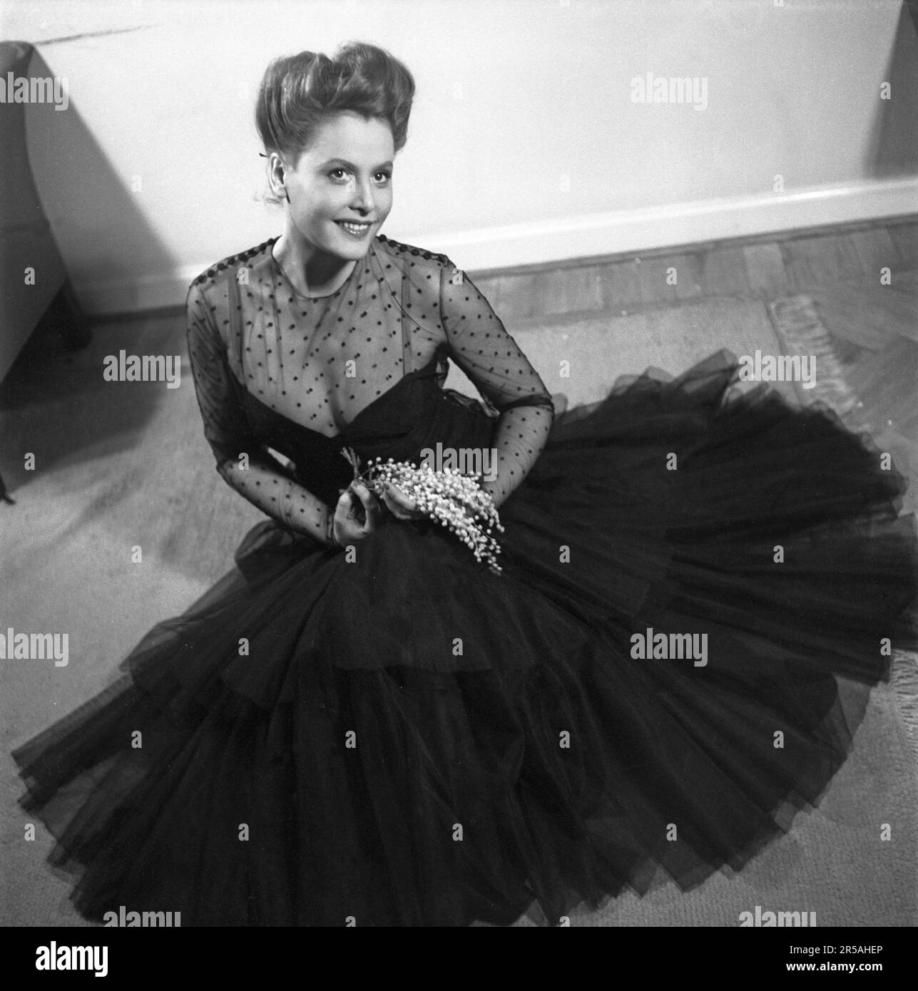 La mode des femmes en 1940s. Une jeune femme dans une robe de soirée typique de 1940s, une robe de soirée de fête noire avec un haut transparent dans un tissu qui voit à travers avec des points décoratifs noirs dessus. Elle est actrice Birgit Tengroth 1915-1983. Suède 1944. Kristoffersson Réf. B145-1 Banque D'Images