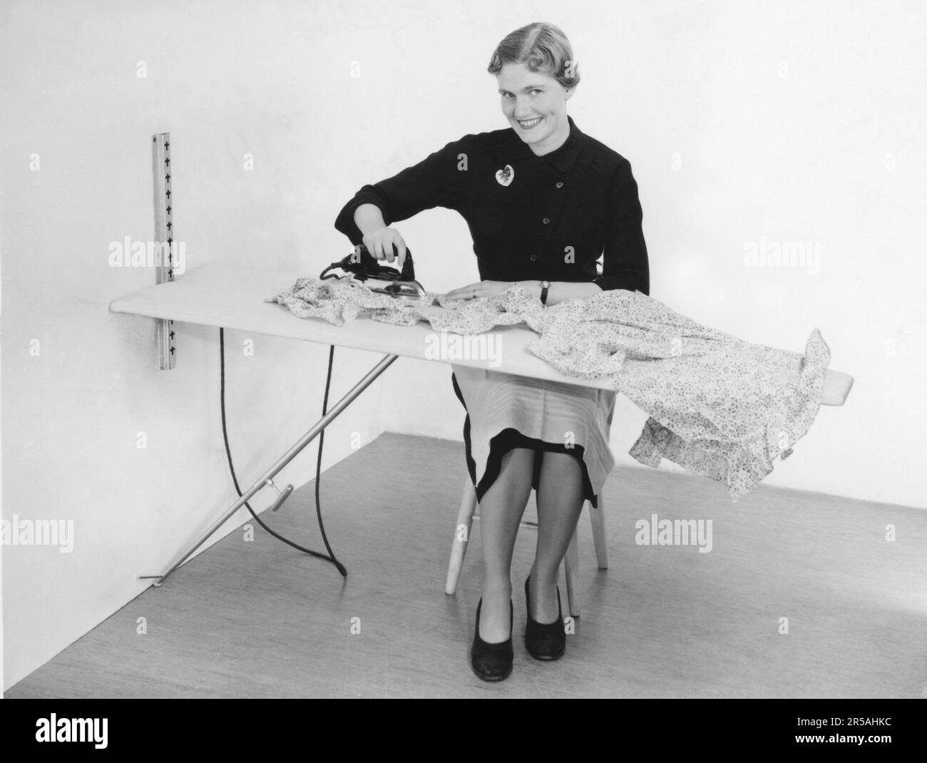 Repassage dans le 1950s. Une femme a vu repasser ses vêtements. Suède 1955. Banque D'Images