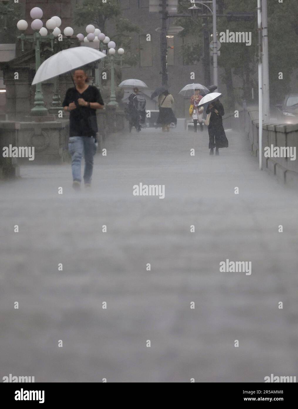 Osaka, Japon, 2 juin 2023, piétons avec parasols descendez une rue au milieu d'une forte pluie dans la ville d'Osaka, dans l'ouest du Japon, sur 2 juin 2023. Un typhon qui s'approche a entraîné des déchetements torrentiels qui ont provoqué des évacuations dans certaines parties du Japon le même jour. (Kyodo)==Kyodo photo via crédit: Newscom/Alay Live News Banque D'Images