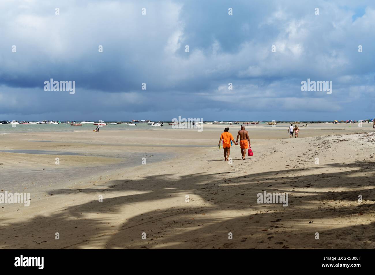 Touristes marchant sur la plage de Porto de Galinhas. Pernambuco, Brésil. Banque D'Images