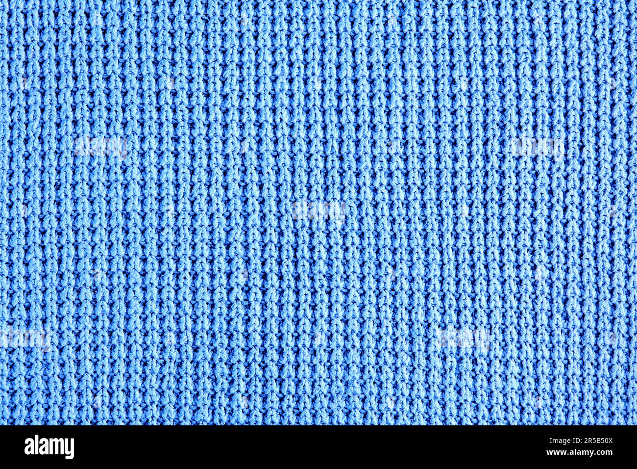 Fragment de vêtements tricotés bleus de tricot rugueux. Arrière-plan pour la conception, la mise en page Banque D'Images
