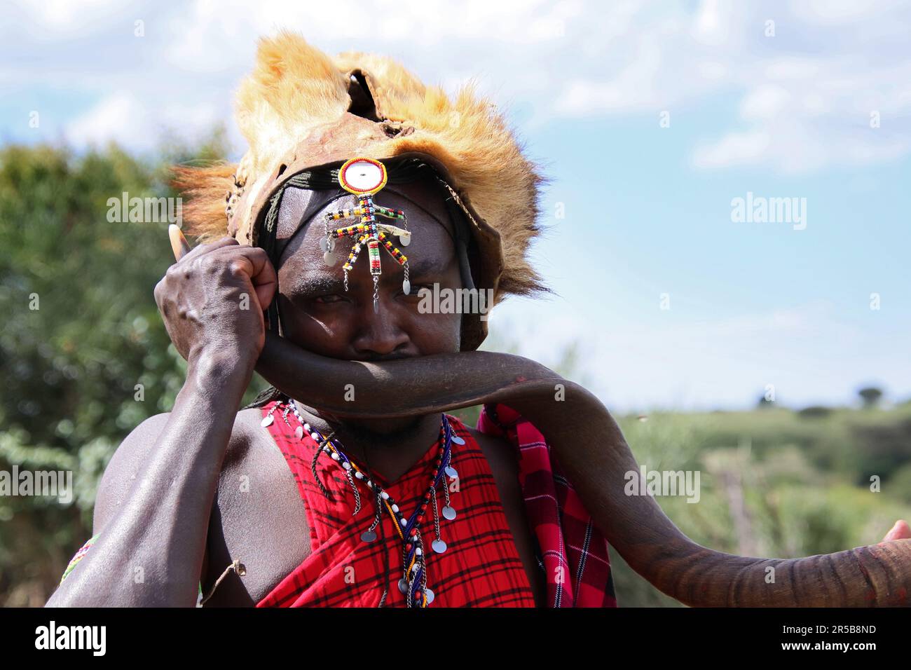 Maasai Mara membre de la tribu lion Mane headdress soufflerie antilope corne utilisé pour appeler les membres de la tribu ou pour la danse tribale et les cérémonies de salutation touristique Banque D'Images