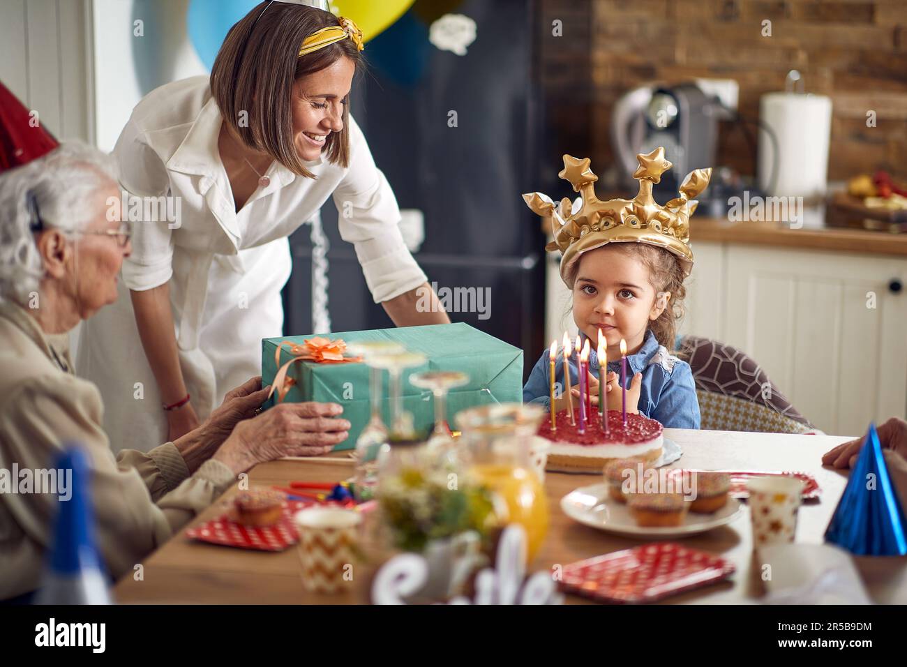 La petite fille reçoit un cadeau spécial de sa grand-mère bien-aimée. Avec des sourires sur leur visage, la grand-mère et la petite-fille partagent une belle liaison de Banque D'Images