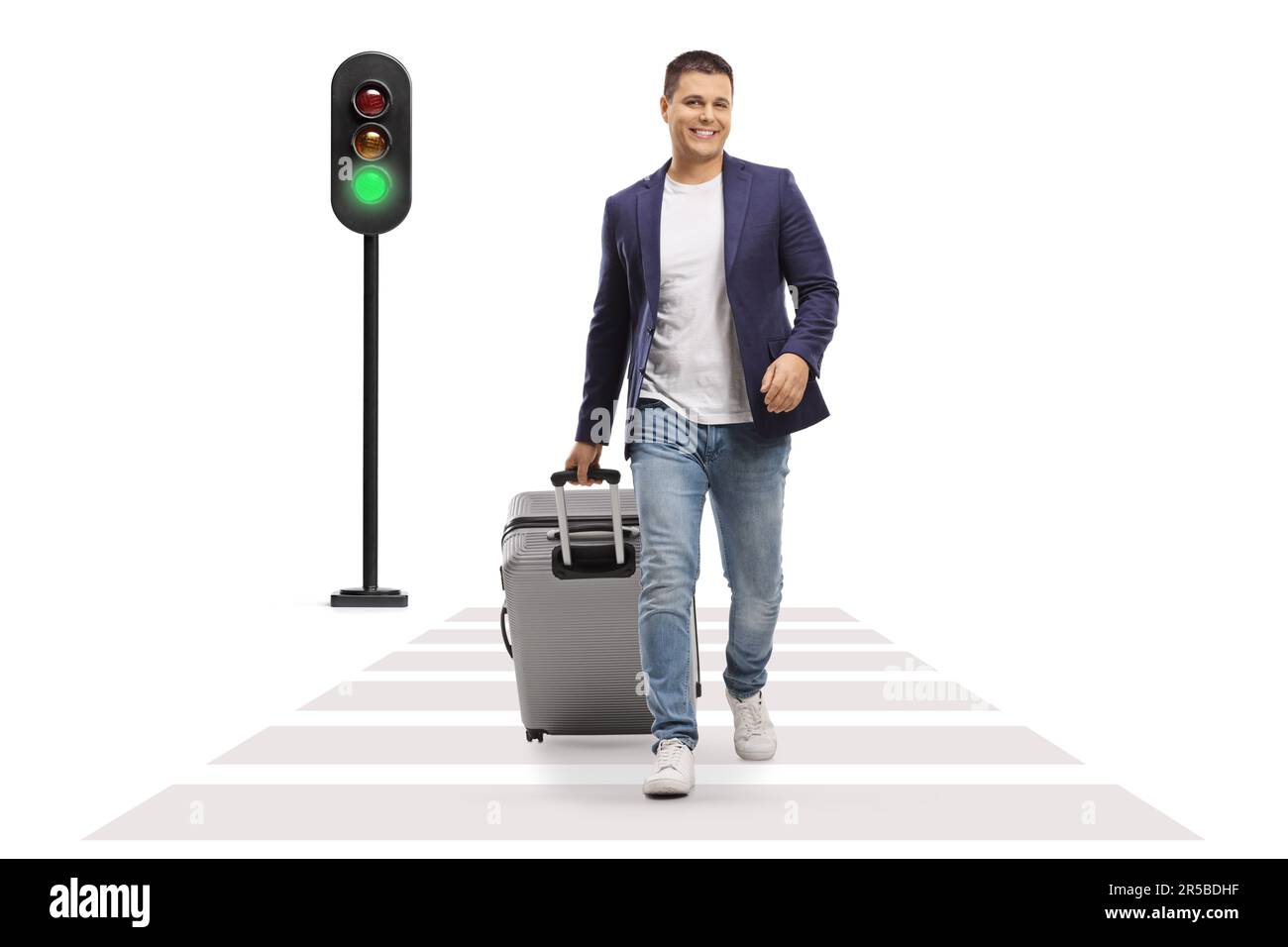Portrait complet d'un homme souriant et marchant avec une valise à une traversée piétonne isolée sur fond blanc Banque D'Images Portrait complet d'un homme souriant et marchant avec une valise à une traversée piétonne isolée sur fond blanc Banque D'Images