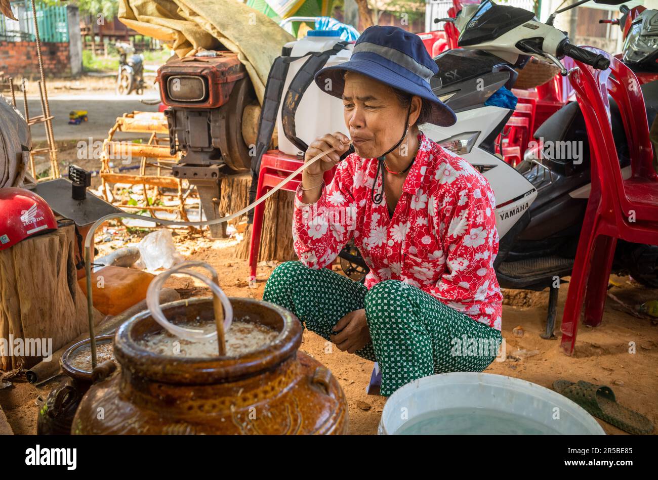 Une femme de la minorité ethnique de Brau boit 'rouou CAN', dans le village de Dak me, la commune de Bo y, le district de Ngoc Hoi, la province de Kontum dans les Hautes-terres centrales Banque D'Images