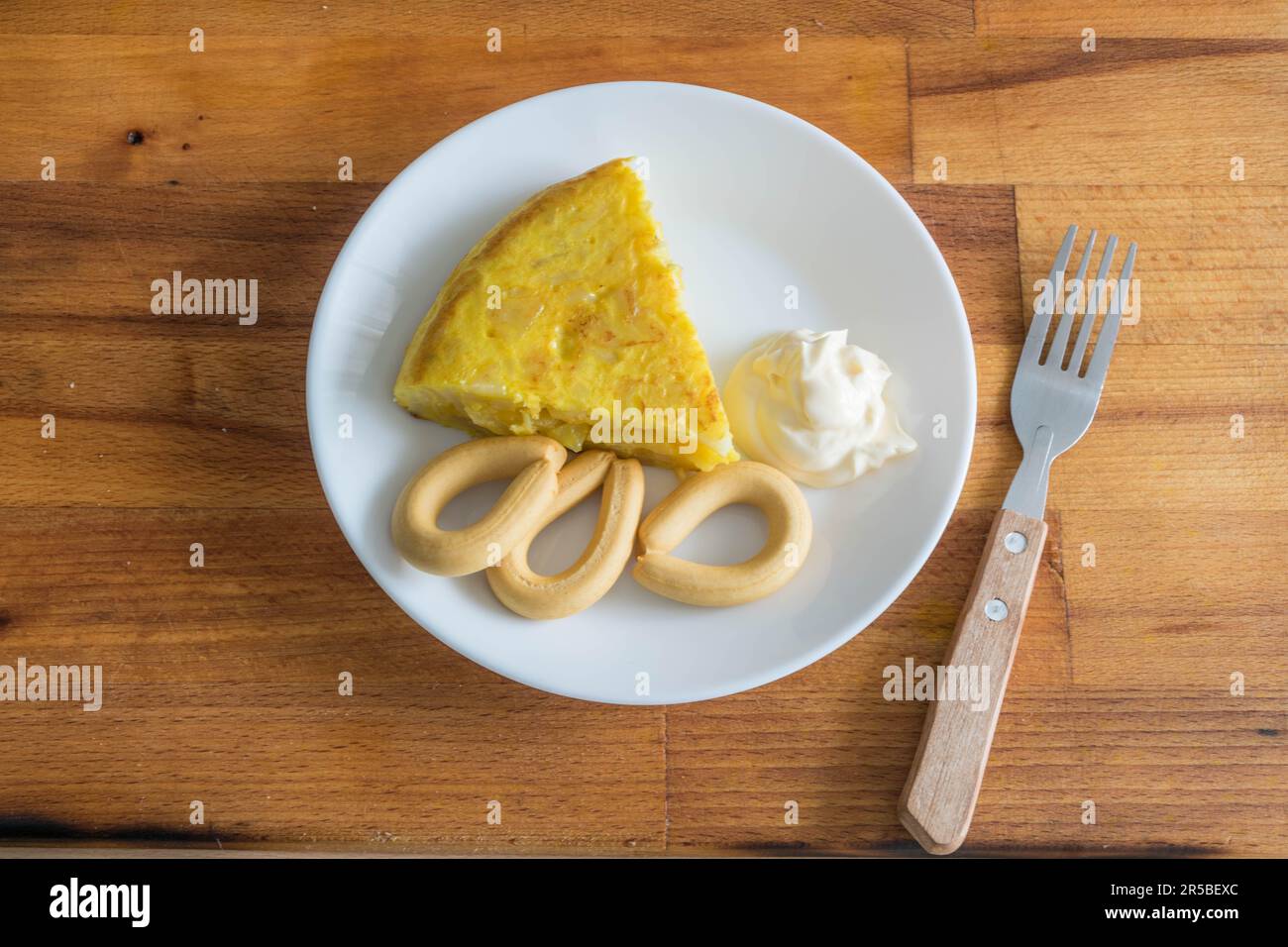 Une assiette blanche avec une variété de plats délicieux, y compris des légumes, des sauces et une coupe de viande, assis à côté d'une fourchette et d'un couteau sur Banque D'Images