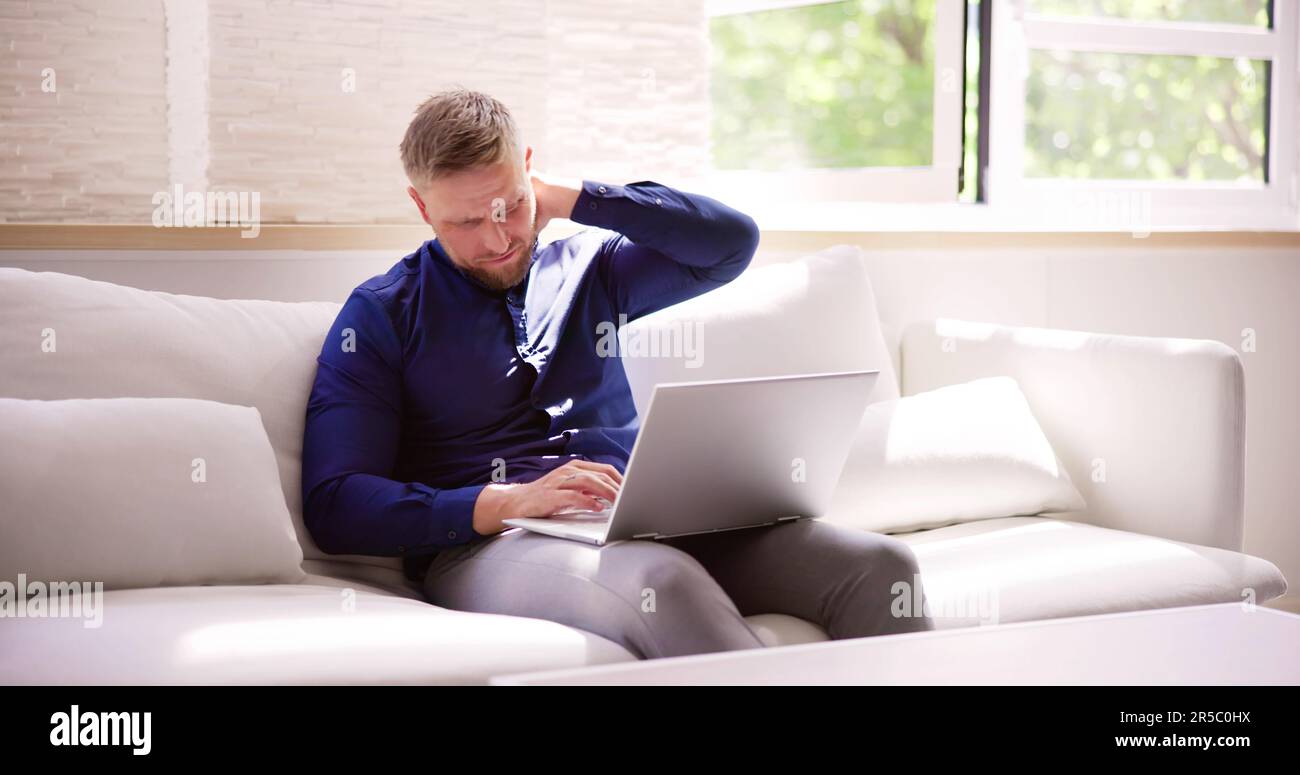 Homme travaillant sur ordinateur portable avec blessure au cou douleur et inflammation Banque D'Images