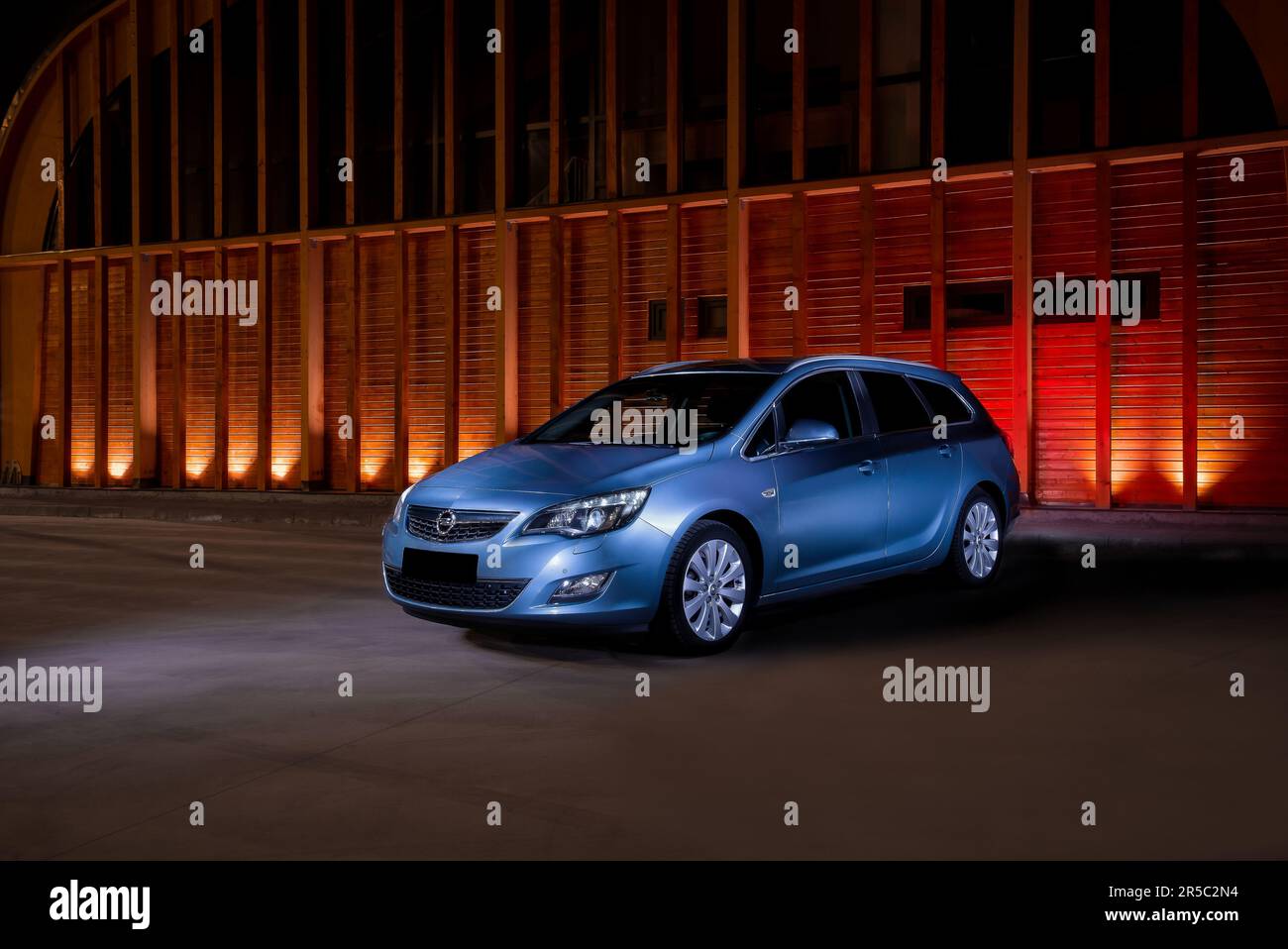 Une voiture Opel Astra J Sports Tourer bleue et élégante, garée près d'un  mur éclairé Photo Stock - Alamy
