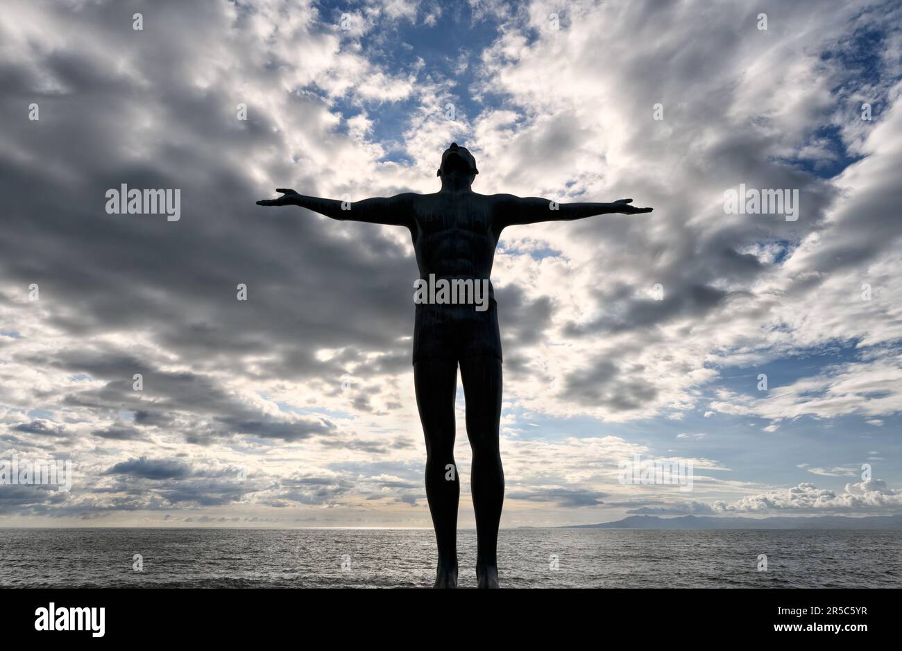 Une silhouette d'homme avec des bras étirés qui regardent vers le ciel Banque D'Images