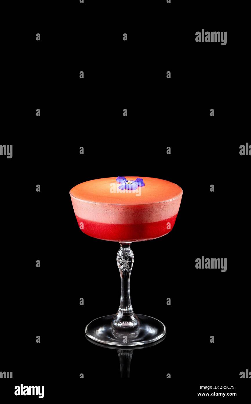 Cocktail de margarita aux fraises d'été avec fleur violette isolée sur fond noir. Cocktail alcoolisé frais. Banque D'Images