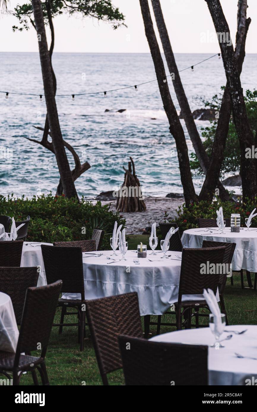 Un restaurant pittoresque en bord de mer entouré d'arbres luxuriants et d'un plan d'eau paisible Banque D'Images