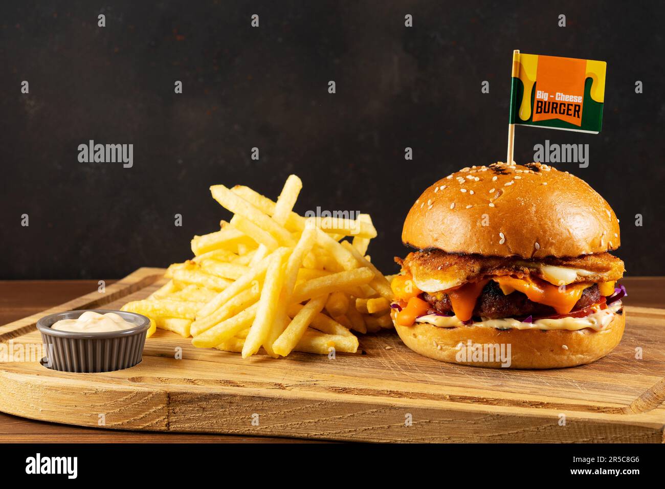 Cheeseburger frais et savoureux avec des pommes de terre poêlées sur une table en bois. Concept de restauration rapide. Banque D'Images
