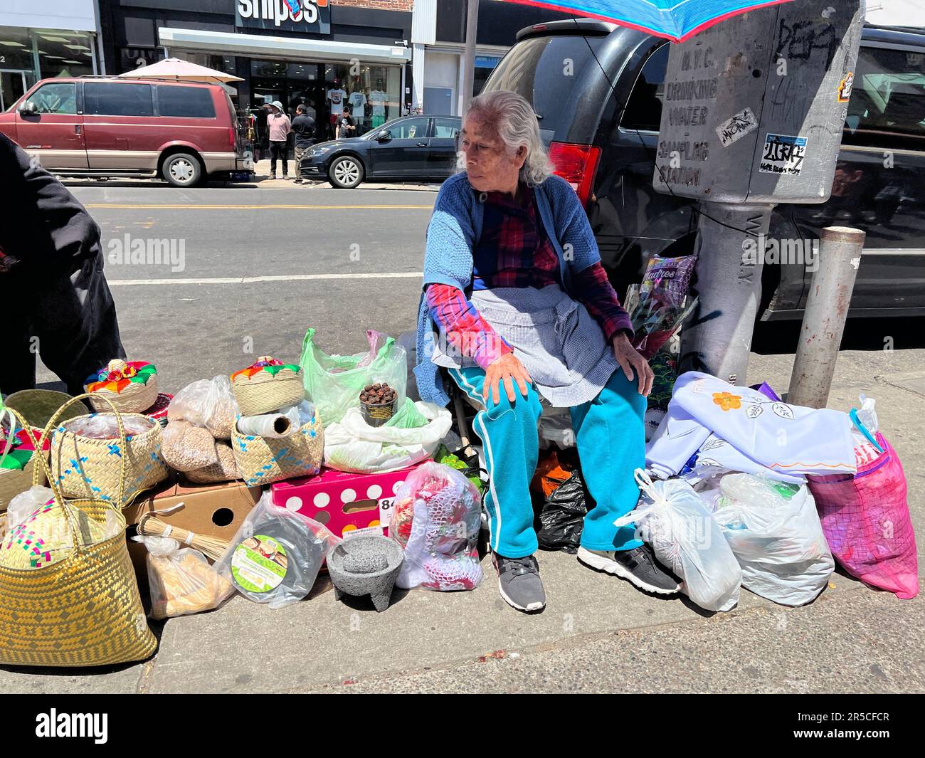 Woman vend diverses marchandises le long du trottoir dans le quartier de Sunset Park à Brooklyn, New York. Banque D'Images