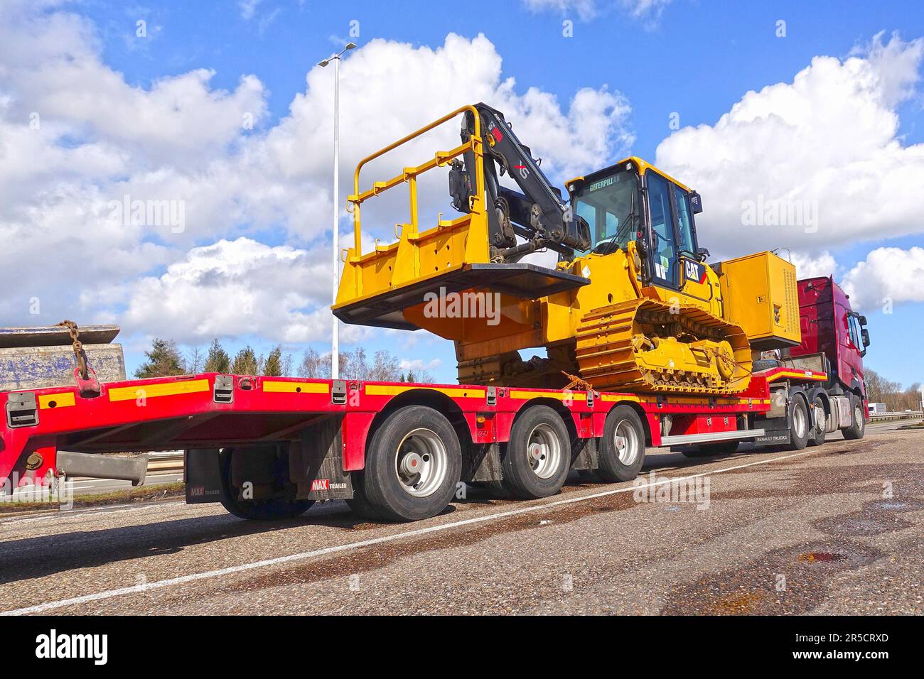 AACHEN, NRW, ALLEMAGNE - 12 mars 2020 : transport lourd d'une grosse chenille sur un camion de remorque spécial à faible charge, stationnement sur un arrêt de camion Banque D'Images