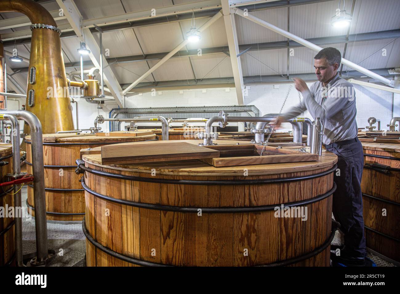 Un travailleur de distillerie qui vérifie le processus de fermentation à la distillerie de l'île de Harris à Tarbert Isle of Harris, Outer Hebrides, en Écosse. Banque D'Images