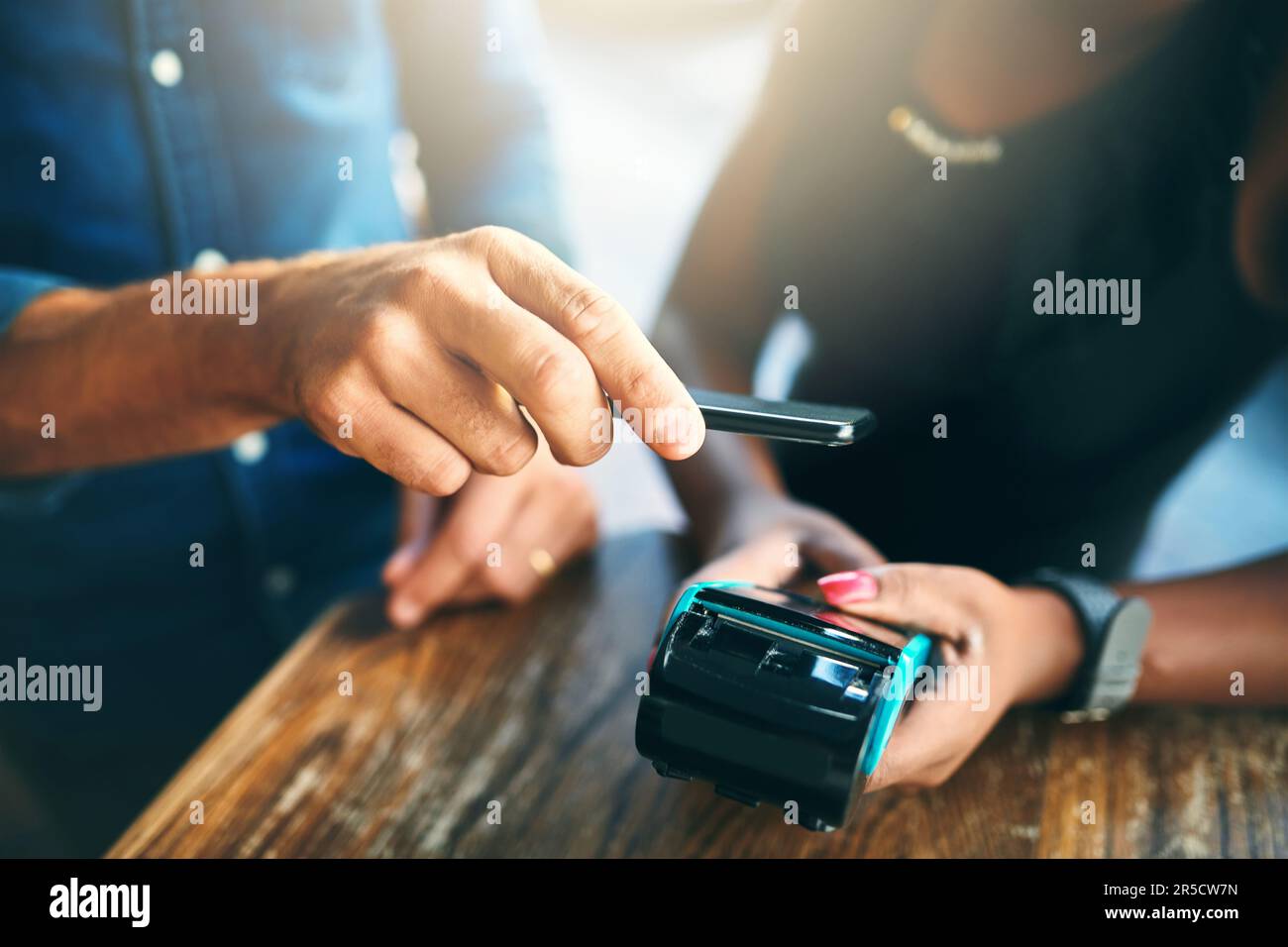 Combien dois-je vous. un homme d'affaires méconnaissable scanne son téléphone portable pour payer sa facture dans un café. Banque D'Images