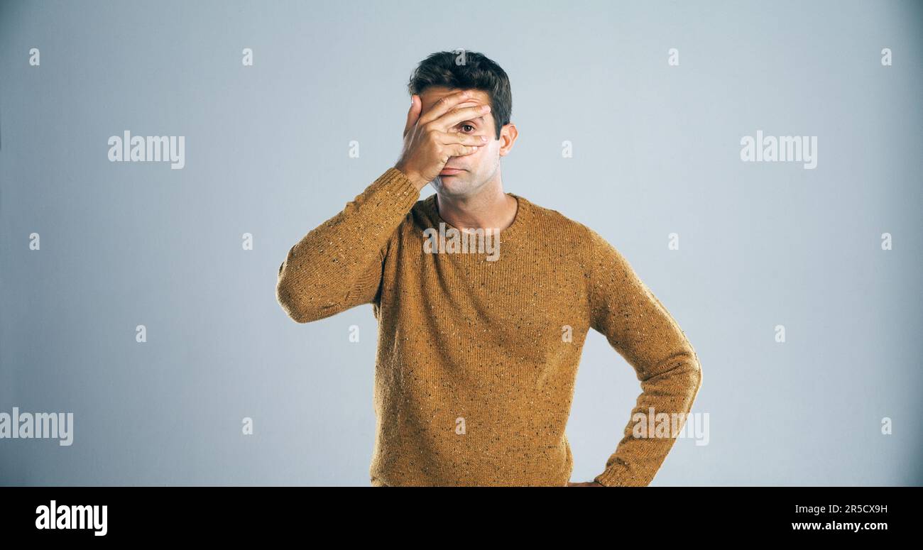 Est-il terminé. Studio photo d'un jeune homme couvrant ses yeux dans la déception sur un fond gris. Banque D'Images