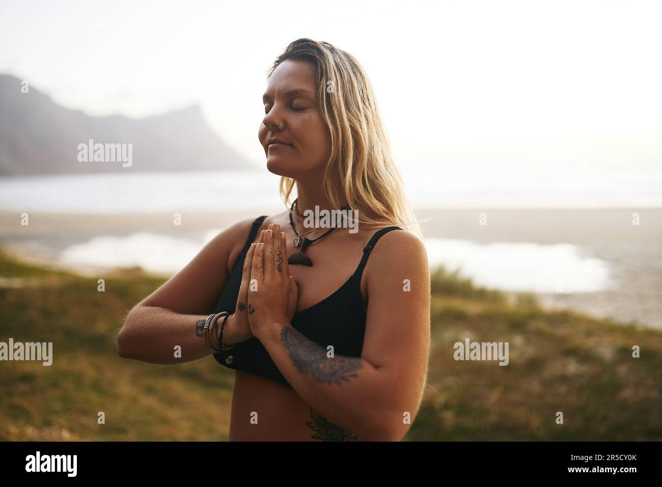 N'oubliez pas de faire preuve de gratitude à travers votre pratique de yoga. une jeune femme attirante debout seule et méditant pendant une journée de détente à l'extérieur. Banque D'Images